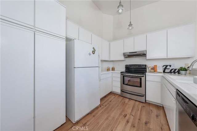 kitchen featuring a sink, stainless steel appliances, light countertops, light wood-style floors, and under cabinet range hood