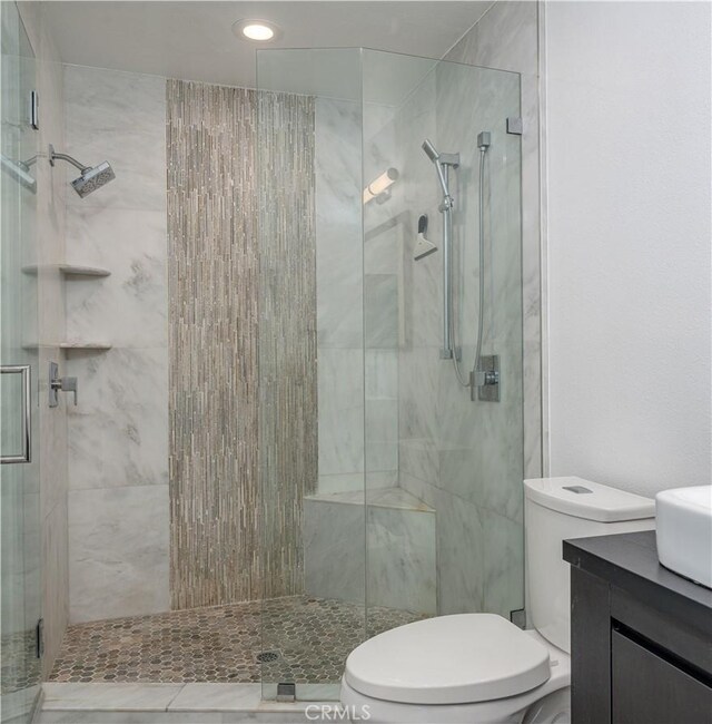 full bathroom with vanity, toilet, and a stall shower