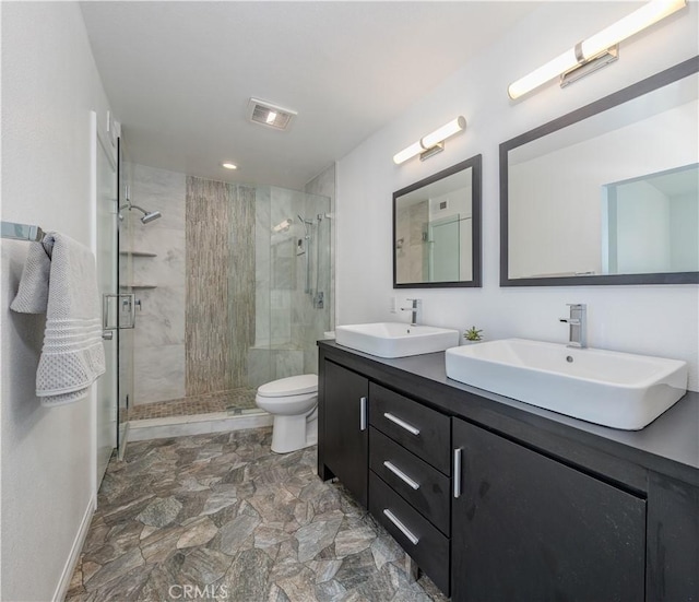 bathroom featuring a shower stall, toilet, visible vents, and a sink