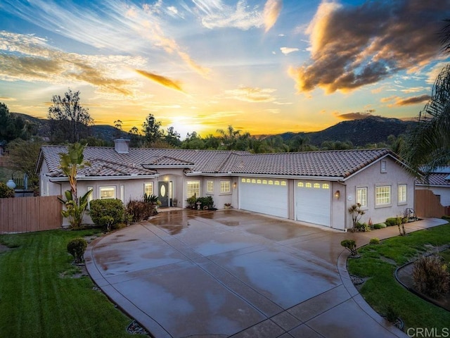 ranch-style home with stucco siding, a garage, and a tile roof