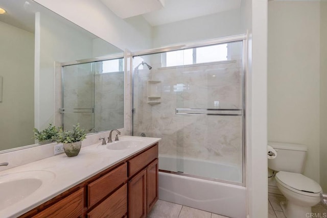 full bath with tile patterned floors, toilet, double vanity, and a sink