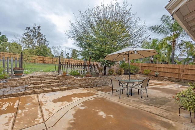 view of patio with outdoor dining area and a fenced backyard