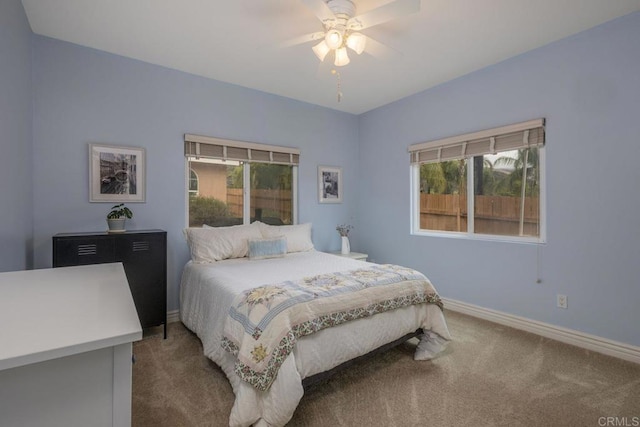 carpeted bedroom with ceiling fan and baseboards