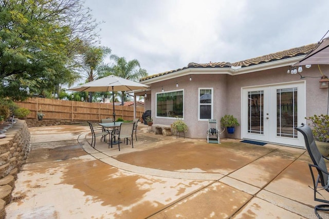 view of patio / terrace with outdoor dining space, french doors, and fence