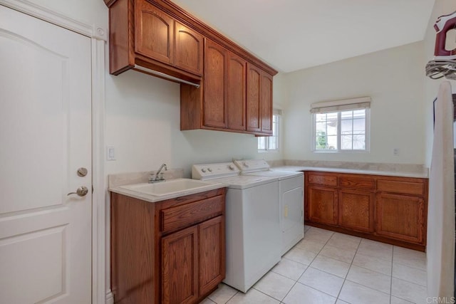 laundry area with a sink, cabinet space, washing machine and dryer, and light tile patterned floors