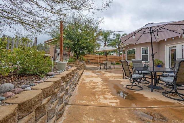 view of patio with outdoor dining area and fence