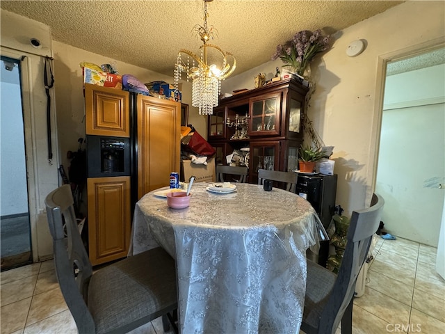 dining area featuring light tile patterned floors, a textured ceiling, and an inviting chandelier