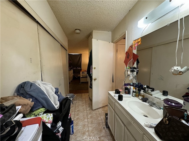 bathroom with a textured ceiling, vanity, and tile patterned flooring