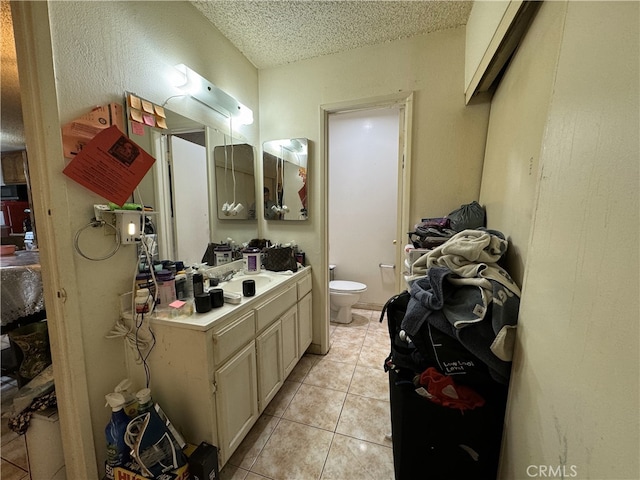 bathroom featuring tile patterned floors, toilet, vanity, and a textured ceiling