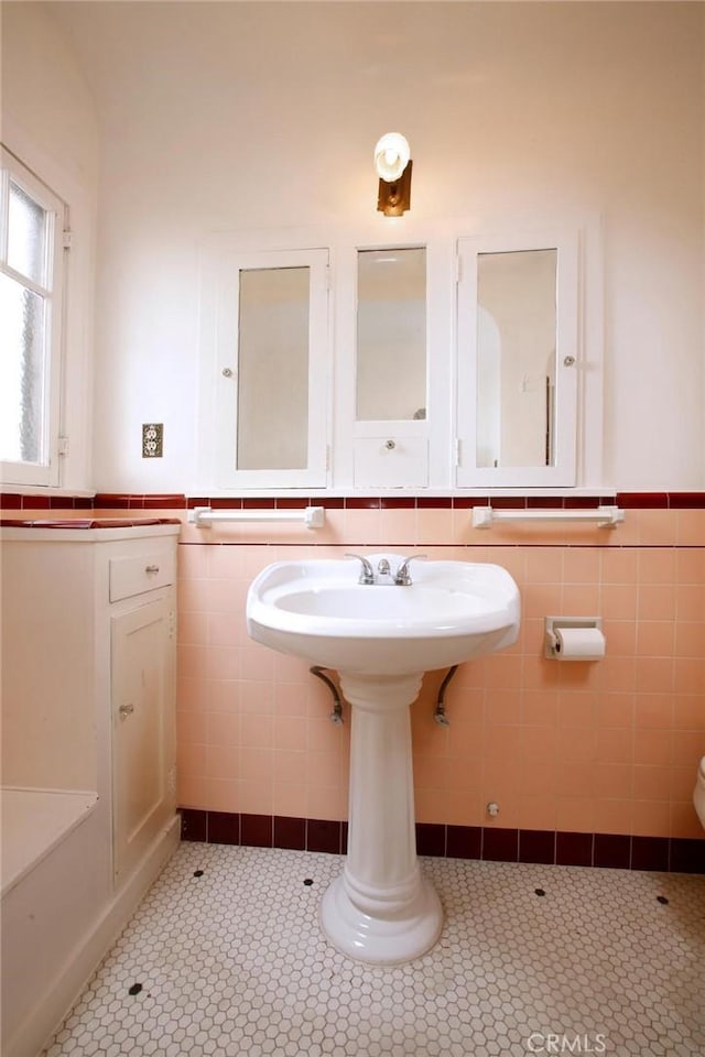 bathroom with tile walls, toilet, and wainscoting