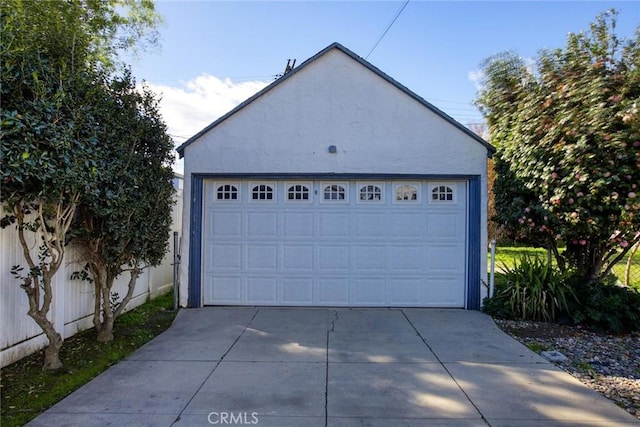 detached garage featuring fence