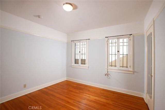 empty room featuring baseboards and wood finished floors