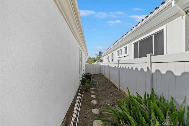 view of home's exterior featuring central air condition unit and fence