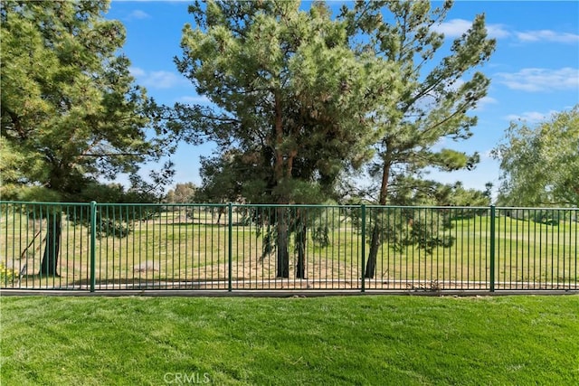 view of gate featuring a lawn and fence