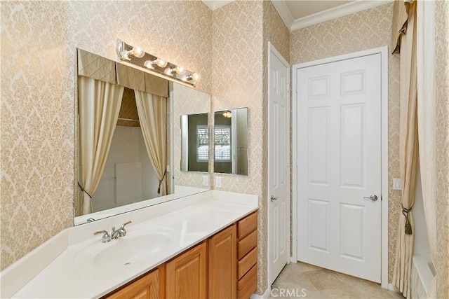 bathroom featuring ornamental molding, vanity, and wallpapered walls