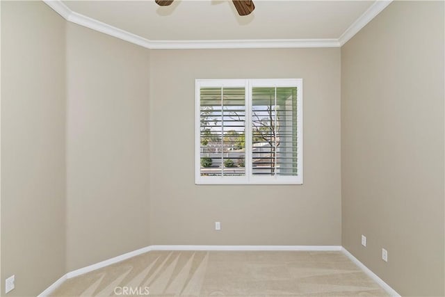 carpeted spare room featuring a ceiling fan, baseboards, and ornamental molding