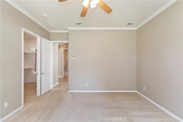 unfurnished bedroom with baseboards, visible vents, ornamental molding, a spacious closet, and light colored carpet