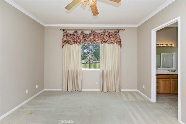 spare room featuring light carpet, baseboards, crown molding, and ceiling fan