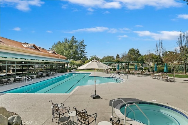 community pool with a community hot tub and a patio area