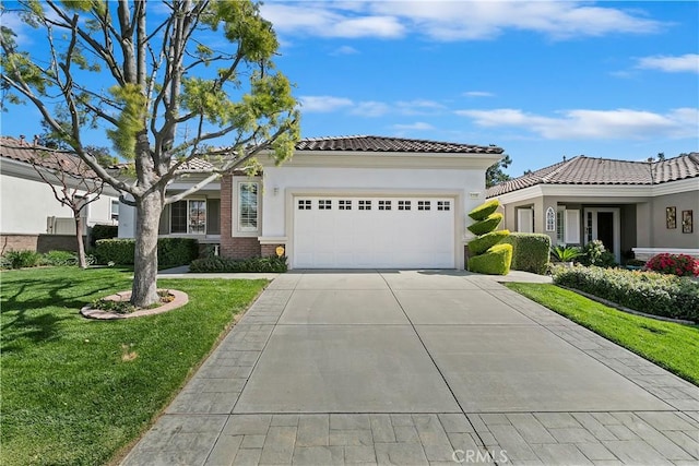 mediterranean / spanish-style house featuring a tile roof, concrete driveway, a front yard, stucco siding, and a garage