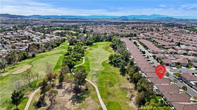 drone / aerial view with view of golf course, a mountain view, and a residential view