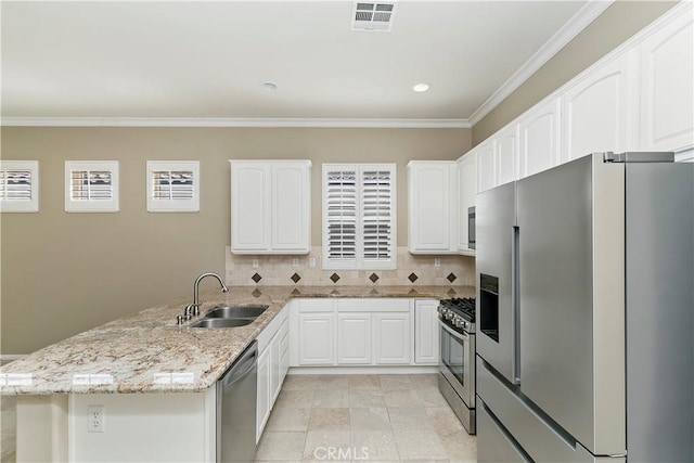 kitchen with light stone countertops, visible vents, a peninsula, a sink, and appliances with stainless steel finishes