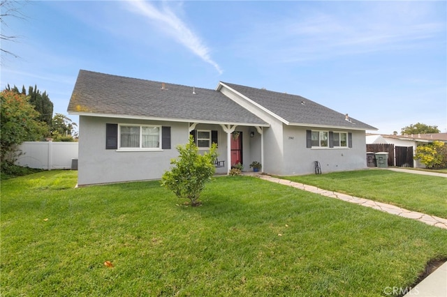 ranch-style house with stucco siding, a shingled roof, a front lawn, and fence