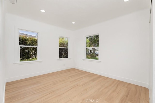 unfurnished room with recessed lighting, light wood-style flooring, and baseboards