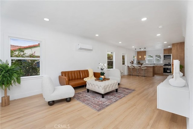 living room with a wealth of natural light, light wood finished floors, recessed lighting, and a wall mounted air conditioner