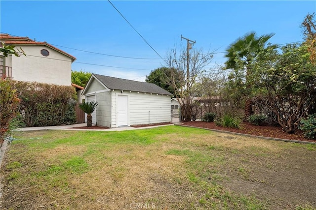 view of yard with a garage, an outdoor structure, and fence