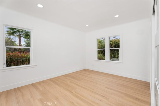 spare room featuring light wood-style flooring, recessed lighting, and baseboards