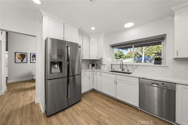 kitchen featuring white cabinetry, stainless steel appliances, and a sink