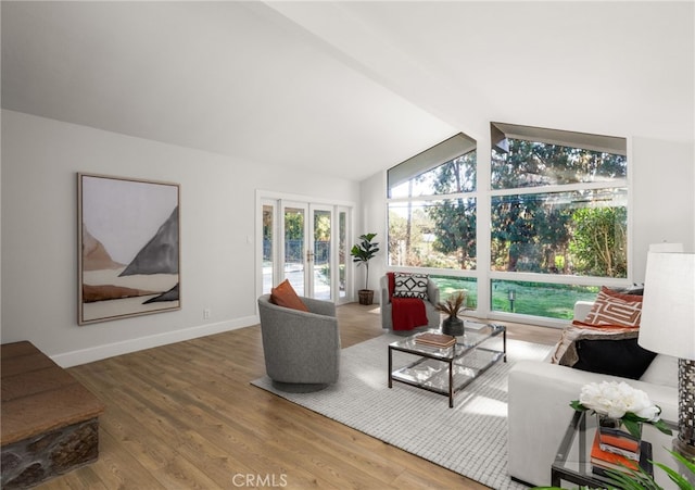 living room with french doors, lofted ceiling with beams, baseboards, and wood finished floors