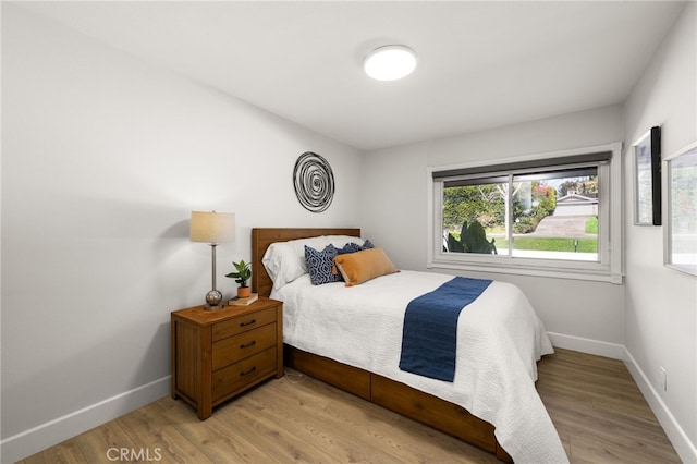 bedroom featuring baseboards and light wood finished floors