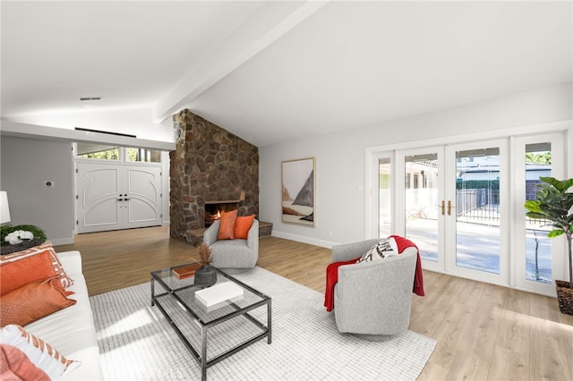 living room featuring baseboards, light wood-type flooring, lofted ceiling with beams, a fireplace, and french doors