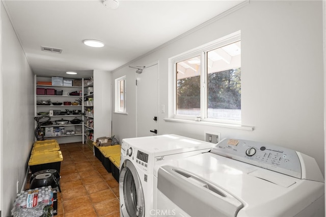 laundry area with visible vents, washing machine and dryer, and laundry area