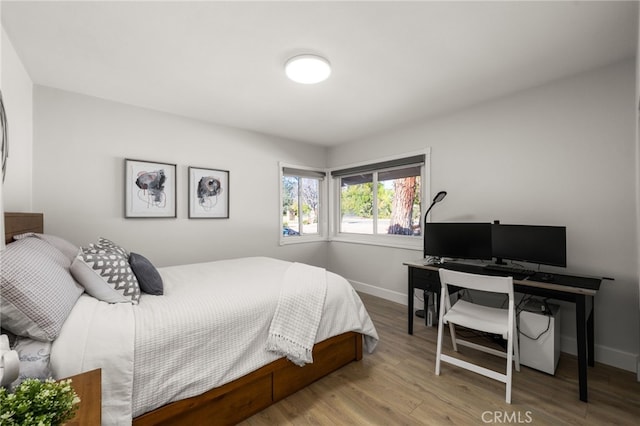 bedroom with baseboards and wood finished floors