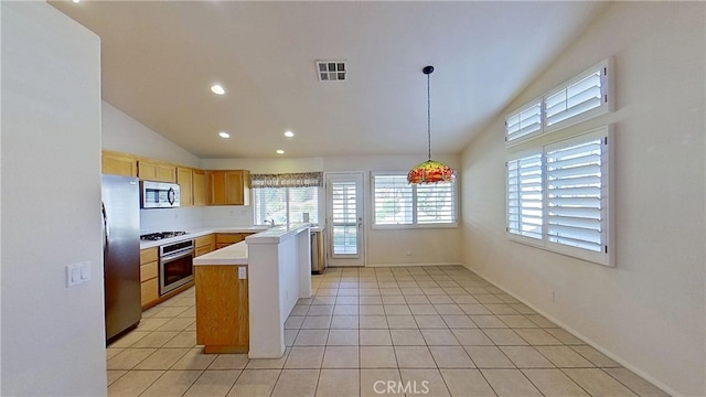 kitchen featuring visible vents, lofted ceiling, light tile patterned flooring, light countertops, and appliances with stainless steel finishes