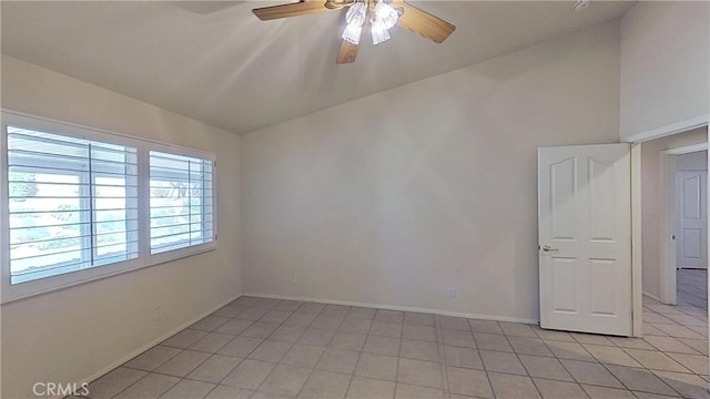 empty room featuring lofted ceiling, baseboards, and ceiling fan