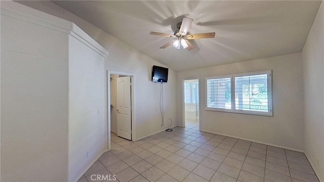 unfurnished room featuring vaulted ceiling, light tile patterned flooring, and a ceiling fan