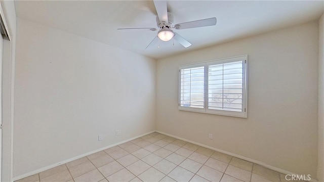 spare room with baseboards and ceiling fan