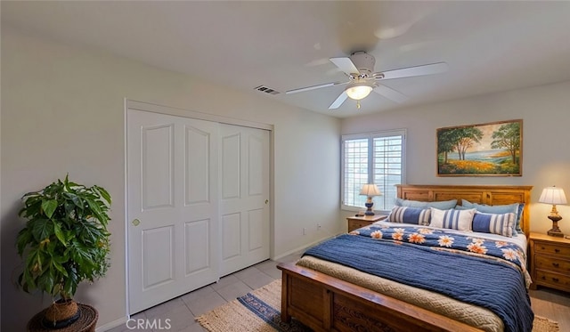 bedroom with visible vents, a ceiling fan, a closet, light tile patterned flooring, and baseboards