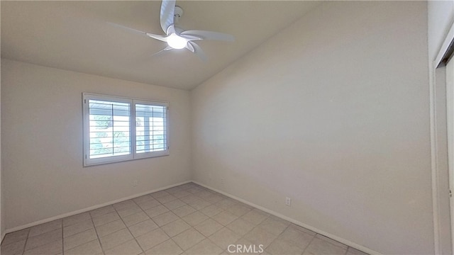 empty room featuring lofted ceiling, baseboards, and ceiling fan