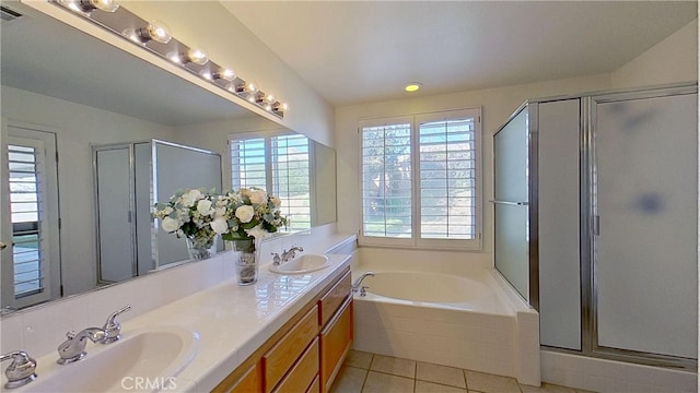 bathroom featuring a garden tub, a healthy amount of sunlight, and a sink