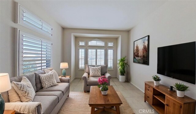 living room featuring baseboards and light tile patterned flooring