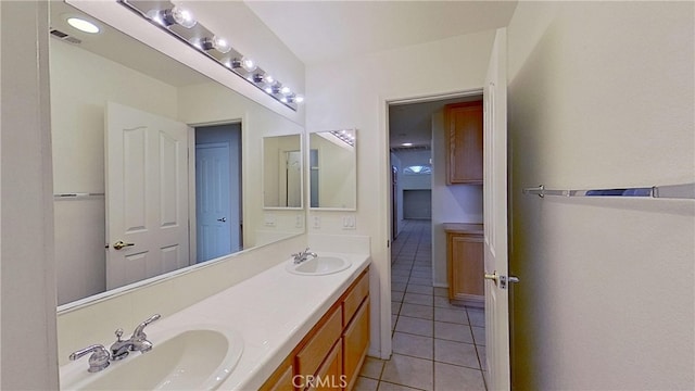 bathroom with tile patterned floors, visible vents, double vanity, and a sink