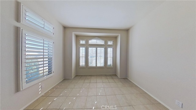 spare room with plenty of natural light and baseboards