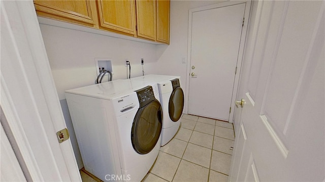 laundry room featuring light tile patterned flooring, washing machine and dryer, and cabinet space