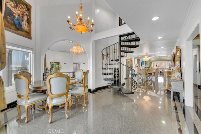 dining space with recessed lighting, stairway, arched walkways, a high ceiling, and a chandelier