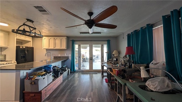 kitchen featuring visible vents, black fridge, a textured ceiling, french doors, and dark wood-style flooring